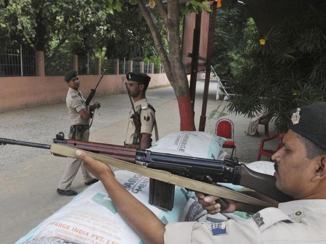 Police personnel stand guard outside a college in Patna where counting of votes will take place. (AP Dube/ht photo)