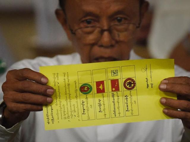In this photo taken on November 8, 2015, a poll official displays a ballot marked for the candidate of Myanmar opposition leader Aung San Suu Kyi's National League for Democracy (NLD) during poll tabulation in Yangon. (AFP Photo)