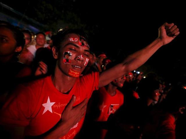 A National League for Democracy (NLD) supporter reacts as others gather beside a large screen showing early election results outside the NLD party office in Mandalay. (AFP Photo) A National League for Democracy (NLD) supporter reacts as others gather beside a large screen showing early election results outside the NLD party office in Mandalay. (AFP Photo)