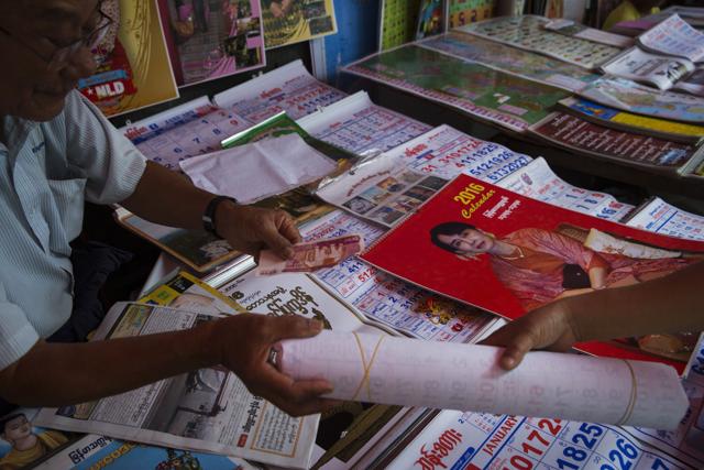 A woman purchases a calendar of Aung San Suu Kyi – who says she plans to circumvent the ban on her becoming president that the generals wrote into the Constitution – in Yangon, Myanmar. (NYT) A woman purchases a calendar of Aung San Suu Kyi – who says she plans to circumvent the ban on her becoming president that the generals wrote into the Constitution – in Yangon, Myanmar. (NYT)
