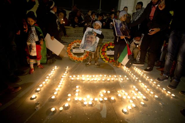 A Palestinian child holds a picture of the late Yasser Arafat, during a candle-lit commemeration at the grave of the late Palestinian leader to mark the 11th anniversary of his death, in the West Bank city of Ramallah. (AP) A Palestinian child holds a picture of the late Yasser Arafat, during a candle-lit commemeration at the grave of the late Palestinian leader to mark the 11th anniversary of his death, in the West Bank city of Ramallah. (AP)