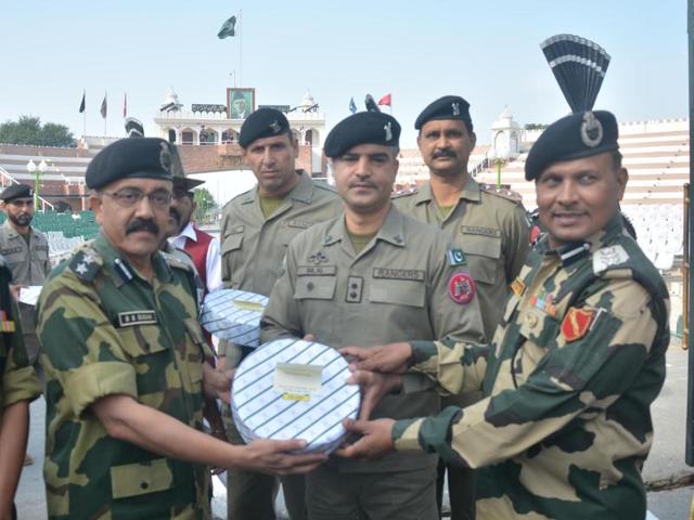 BSF officials exchanging sweets with Pakistani Rangers to celebrate Diwali at Indo-Pak Border at Attari near Amritsar on Wednesday. (Sameer Sehgal / HT )
