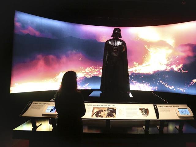 A woman looks at a Darth Vader costume used in Star Wars movies at the Discovery Store Times Square, New York. (REUTERS)