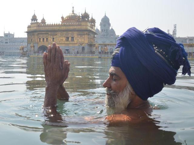 A Sikh devotee taking dip in the Sarovar of the Golden Temple on the occasion of Diwali. (Sameer Sehgal/HT) A Sikh devotee taking dip in the Sarovar of the Golden Temple on the occasion of Diwali. (Sameer Sehgal/HT)