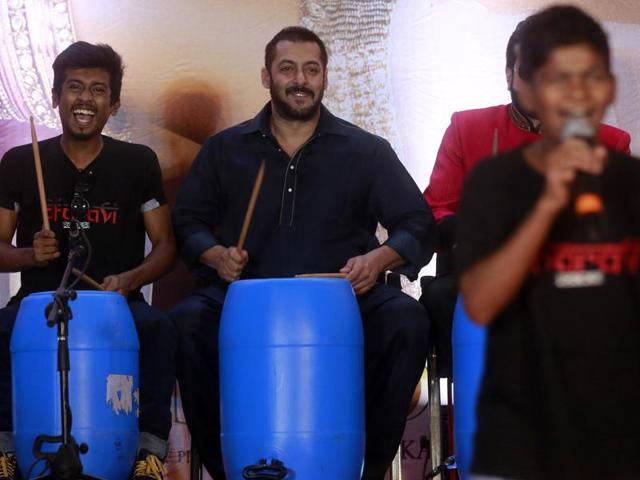 Salman Khan, center, beats on a percussion instrument made with recyclable items with children from Dharavi slum in Mumbai, on Wednesday, (AP)