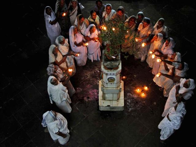 Hindu widows perform rituals near a tulsi plant, believed to be sacred by Hindus, at a Dharamshala during Diwali in Bhubaneswar, India. (AP)