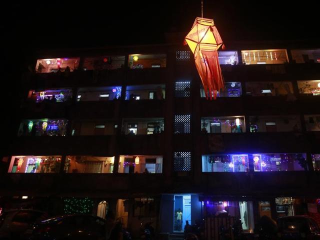 A tenement block housing mostly fishermen families is illuminated with lights during Diwali in Mumbai . (AP)