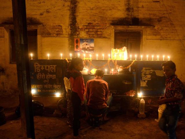 An roadside shopkeeper lights candles on his cart after performing a puja to celebrate Diwali in Allahabad on November 11, 2015. (AFP)