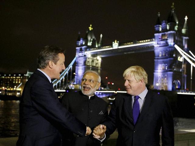 Britain's Prime Minister David Cameron, left, with India's Prime Minister Narendra Modi, centre, and the Mayor of London Boris Johnson, right, hold hands in front of Tower Bridge in London, Thursday, (AP)