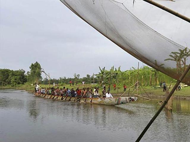 Participants paddle a country boat during a traditional boat race at Dashiachora, in Kurigram enclaves, Bangladesh. Bangladesh and India exchanged enclaves in July, where the two neighbouring countries now implement the Land Boundary Agreement in line with a deal signed in 1974. (AP File Photo) Participants paddle a country boat during a traditional boat race at Dashiachora, in Kurigram enclaves, Bangladesh. Bangladesh and India exchanged enclaves in July, where the two neighbouring countries now implement the Land Boundary Agreement in line with a deal signed in 1974. (AP File Photo)