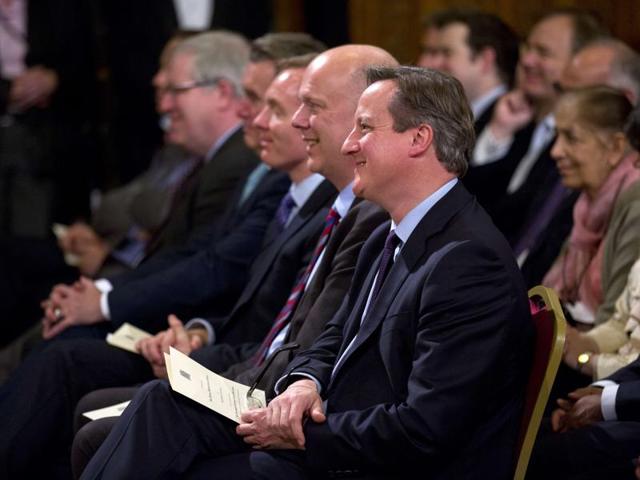 British Prime Minister David Cameron (C) listens as Indian Prime Minister Narendra Modi (unseen) addresses members of parliament and invited guests in the Royal Gallery at the Houses of Parliament in central London on November 12, 2015 as Britain's Speaker of the House of Commons John Bercow (L) listens. (AFP)