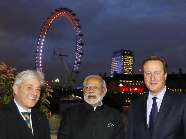 Britain's Prime Minister David Cameron (R) India's Prime Minister Narendra Modi (C) and Speaker of the House of Commons John Bercow (L) stand together during Modi's tour of Parliament with the London Eye in the background in London on November 12, 2015. (AFP)