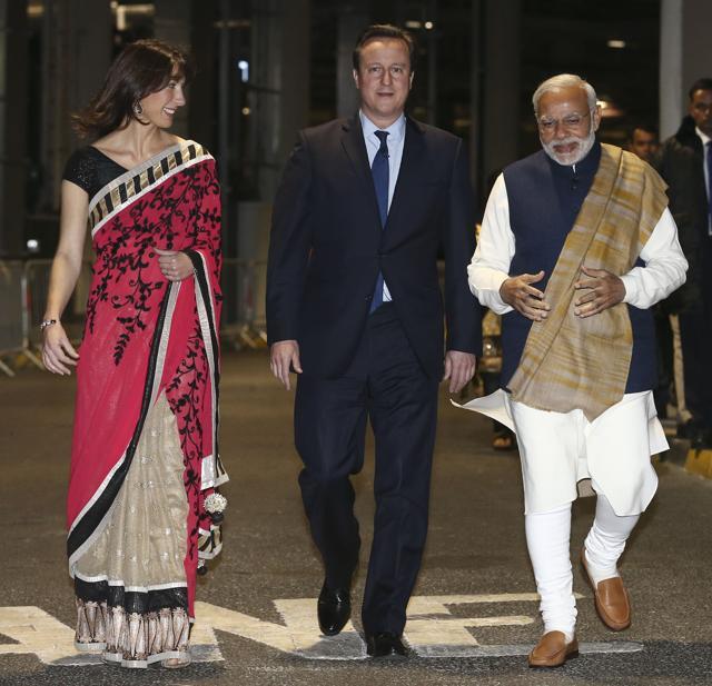 Prime Minister Narendra Modi (R) walks with British Prime Minister David Cameron (C) and his wife Samantha (L) in a backstage area at Wembley Stadium in London. (AFP) Prime Minister Narendra Modi (R) walks with British Prime Minister David Cameron (C) and his wife Samantha (L) in a backstage area at Wembley Stadium in London. (AFP)