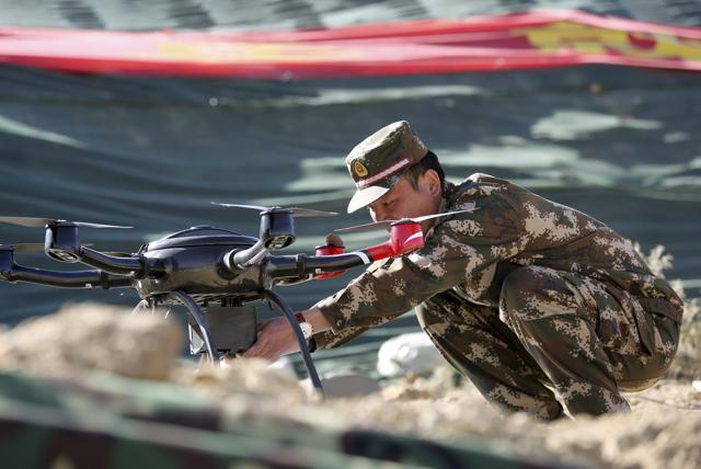 A police officer prepares a drone for display during a drill at a military base in Shigatse, Tibet Autonomous Region, China, October 25, 2015. (REUTERS) A police officer prepares a drone for display during a drill at a military base in Shigatse, Tibet Autonomous Region, China, October 25, 2015. (REUTERS)