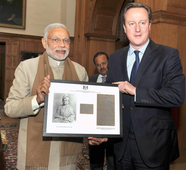 Prime Minister Narendra Modi presenting a gift to the Prime Minister of United Kingdom (UK), David Cameron in London on Friday. (PTI Photo) Prime Minister Narendra Modi presenting a gift to the Prime Minister of United Kingdom (UK), David Cameron in London on Friday. (PTI Photo)