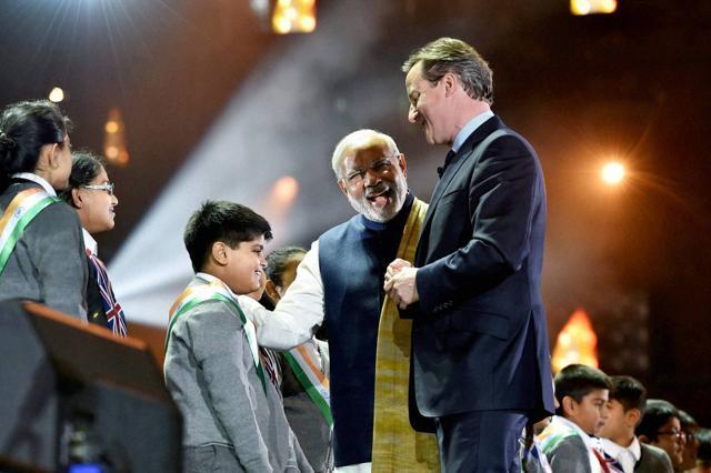 Prime Minister Narendra Modi with his UK counterpart David Cameron interact with school children at Wembley Stadium for addressing Indian Community in London. (PTI) Prime Minister Narendra Modi with his UK counterpart David Cameron interact with school children at Wembley Stadium for addressing Indian Community in London. (PTI)