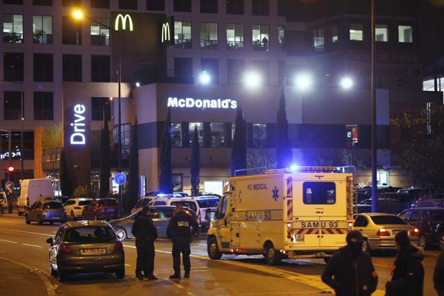 Police and rescuers gather in front of a fast-food drive restaurant outside the Stade de France stadium in Saint-Denis, north of Paris, late on November 13, 2015. (AFP Photo)