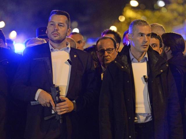 French President Francois Hollande (Rear C), protected by armed bodyguards, stands near the Bataclan concert hall in central Paris. (AFP)