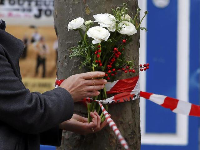 A man puts flowers near the French embassy to commemorate victims of attacks in Paris.(Reuters)