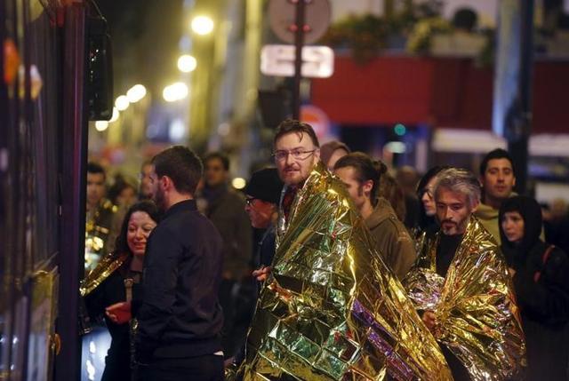 People warm up under protective thermal blankets as they prepare to board a bus to be evacuated near the Bataclan concert hall following fatal attacks in Paris. (Reuters) People warm up under protective thermal blankets as they prepare to board a bus to be evacuated near the Bataclan concert hall following fatal attacks in Paris. (Reuters)