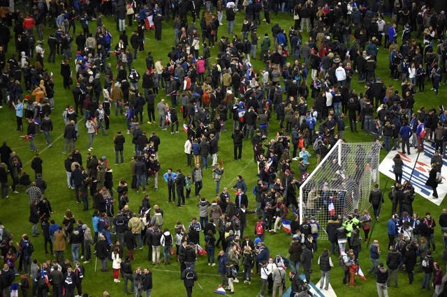 Football fans gather in the field as they wait for security clearance to leave the Stade de France in Saint-Denis, north of Paris. (AFP Photo)