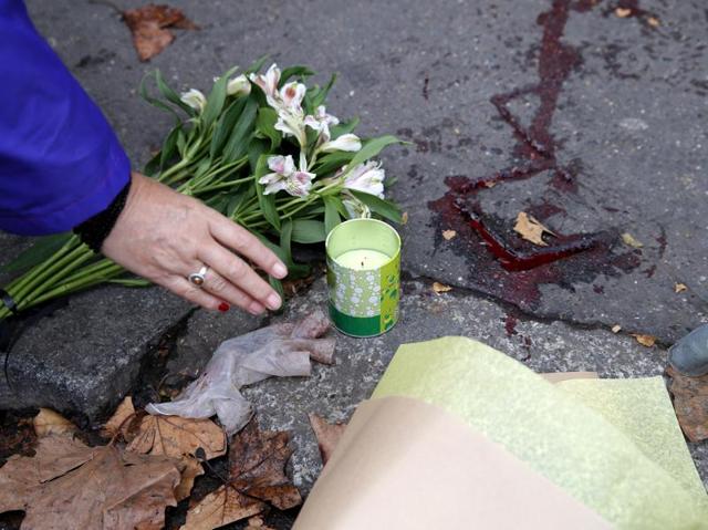 A woman places a candle outside the Bataclan concert hall, Saturday, Nov. 14, 2015 in Paris. (AP Photo)