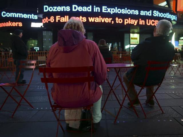 People watch as a news ticker updates people with the news of the shooting attacks in Paris, in Times Square in the Manhattan borough of New York. (REUTERS)