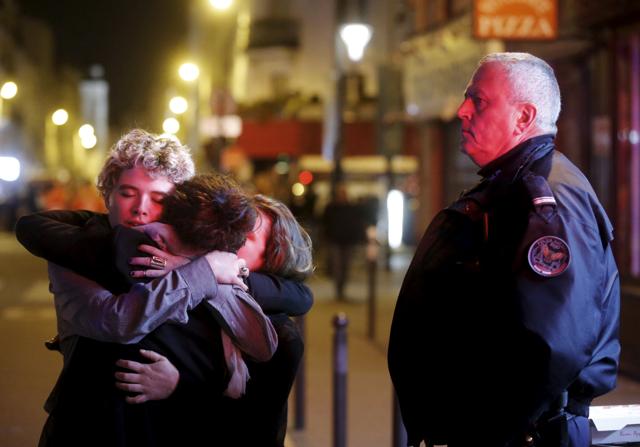 People hug on the street near the Bataclan concert hall. (Reuters)