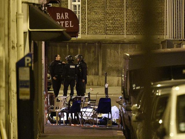 A victim lies on the ground covered by a white sheet following an attack at rue Bichat. (AFP)