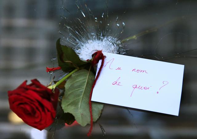 A rose placed in a bullet hole in a restaurant window the day after a series of deadly attacks in Paris . The note reads "In the Name of What?" (Reuters Photo) A rose placed in a bullet hole in a restaurant window the day after a series of deadly attacks in Paris . The note reads "In the Name of What?" (Reuters Photo)