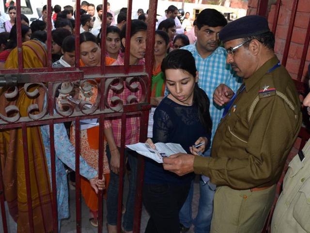 Police officials checking documents of candidates outside an examination centre at Rohtak on Saturday. (HT Photo) Police officials checking documents of candidates outside an examination centre at Rohtak on Saturday. (HT Photo)