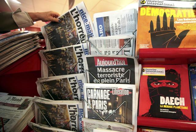 A woman takes the local newspaper at a news stand which displays a magazine (R bottom) which reads "Daech, the planetary threat" . (REUTERS) A woman takes the local newspaper at a news stand which displays a magazine (R bottom) which reads "Daech, the planetary threat" . (REUTERS)