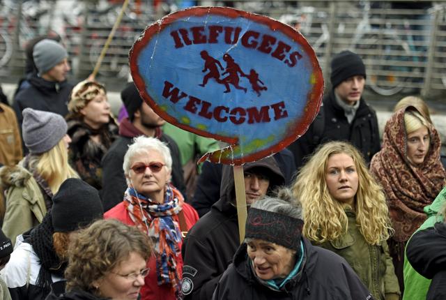 A protestor holds up a sign during a pro-refugee demonstration in downtown Hamburg, Germany. (REUTERS) A protestor holds up a sign during a pro-refugee demonstration in downtown Hamburg, Germany. (REUTERS)