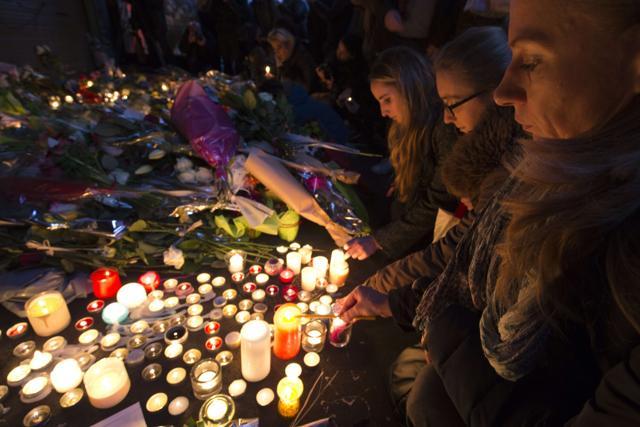 People light candles at a pop-up memorial to the victims of the Paris' attacks rue de Charonne in Paris. (AFP) People light candles at a pop-up memorial to the victims of the Paris' attacks rue de Charonne in Paris. (AFP)