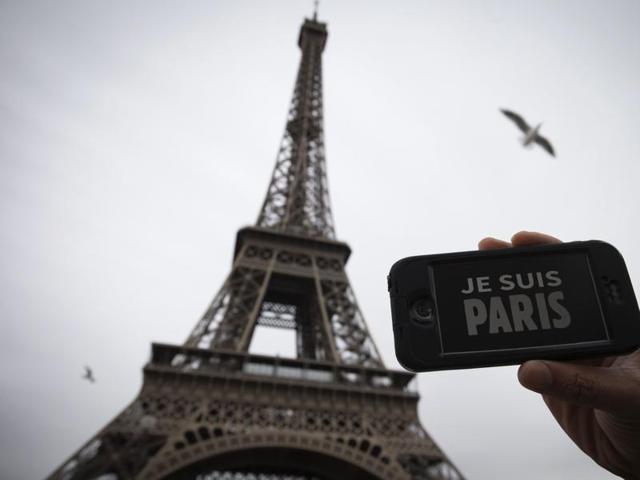 In this illustration picture taken in Paris on November 14, 2015 a person holds aloft a smartphone bearing the message "Je Suis Paris" in front of the Eiffel Tower.(AFP)