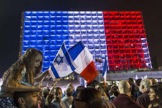 People attend a gathering to honor the victims of the Paris attacks in front of the Tel Aviv city hall, that is lit with the colors of the French national flag in Tel Aviv. (AFP Photo) People attend a gathering to honor the victims of the Paris attacks in front of the Tel Aviv city hall, that is lit with the colors of the French national flag in Tel Aviv. (AFP Photo)