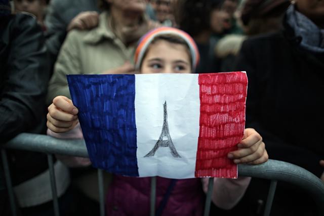 A child holds-up a hand drawn French flag as people gather on in Turin, a day after deadly attacks in Paris. (AFP) A child holds-up a hand drawn French flag as people gather on in Turin, a day after deadly attacks in Paris. (AFP)