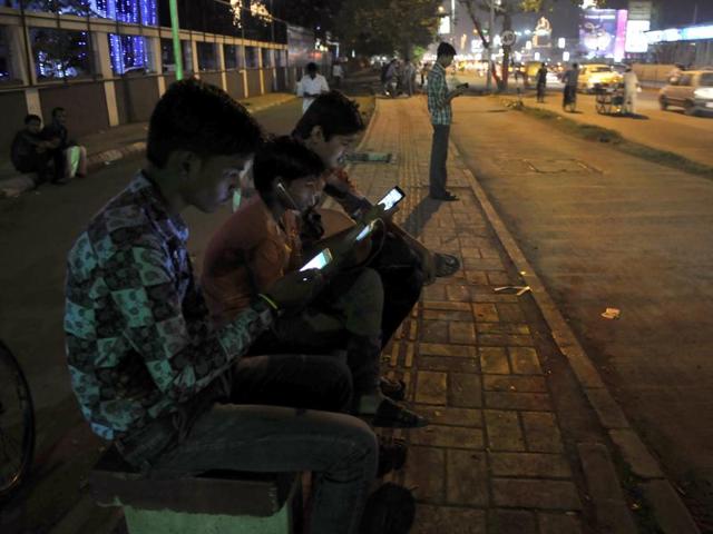 Youngsters glued to their mobile phones at one of the Wi-Fi zones in Indore on Saturday.(Arun Mondhe/HT photo)