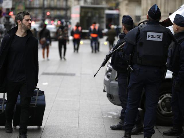 A traveller (L) walks past policemen standing guard outside the Gare du Nord railway station on November 16, 2015 in Paris. (AFP Photo) A traveller (L) walks past policemen standing guard outside the Gare du Nord railway station on November 16, 2015 in Paris. (AFP Photo)