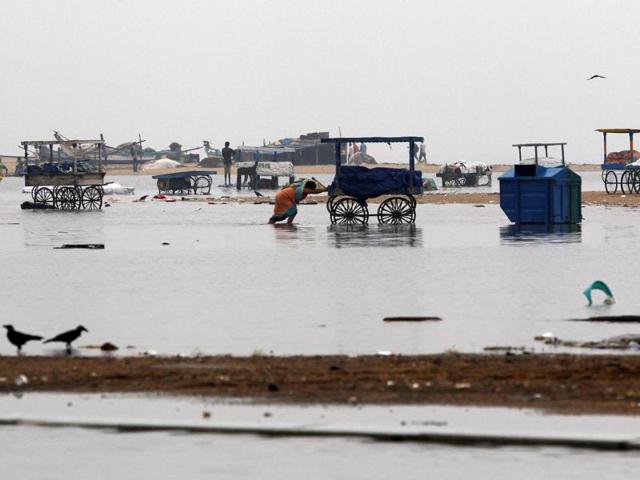 Woman pushes a cart on the waterlogged Marina Beach after heavy rainfall in Chennai (AP) Woman pushes a cart on the waterlogged Marina Beach after heavy rainfall in Chennai (AP)