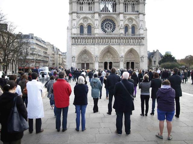 People observe a minute of silence in front of the Notre Dame Cathedral in Paris to pay tribute to victims of Friday's Paris attacks, France. (REUTERS Photo) People observe a minute of silence in front of the Notre Dame Cathedral in Paris to pay tribute to victims of Friday's Paris attacks, France. (REUTERS Photo)