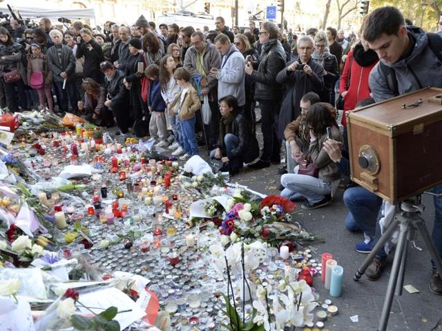 People gather in front of a memorial along a police cordon set-up close to the Bataclan concert hall. (AFP) People gather in front of a memorial along a police cordon set-up close to the Bataclan concert hall. (AFP)