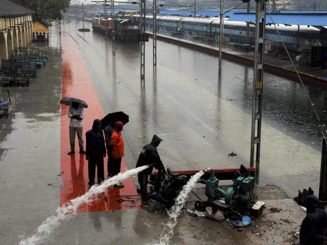Railway workers pumping out the rainwater from tracks at inundated Vyasarpadi railway station after heavy rains in Chennai on Friday. (PTI) Railway workers pumping out the rainwater from tracks at inundated Vyasarpadi railway station after heavy rains in Chennai on Friday. (PTI)