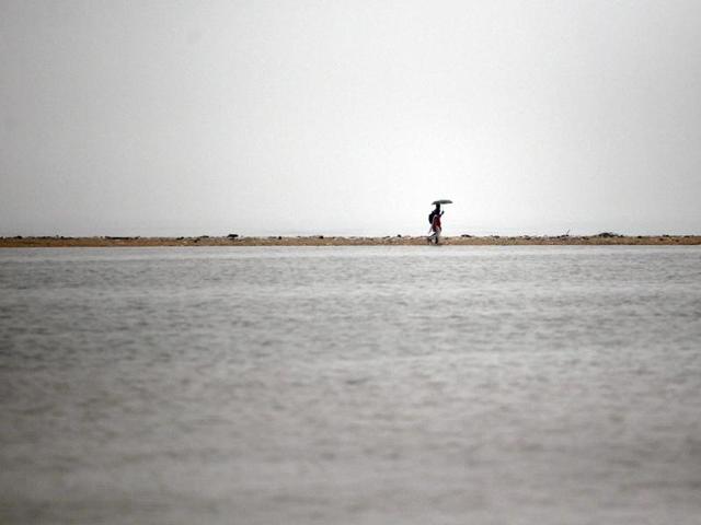 Indian couple walks on a dry stretch of land on the waterlogged Marina Beach after heavy rainfall in Chennai. (AP) Indian couple walks on a dry stretch of land on the waterlogged Marina Beach after heavy rainfall in Chennai. (AP)