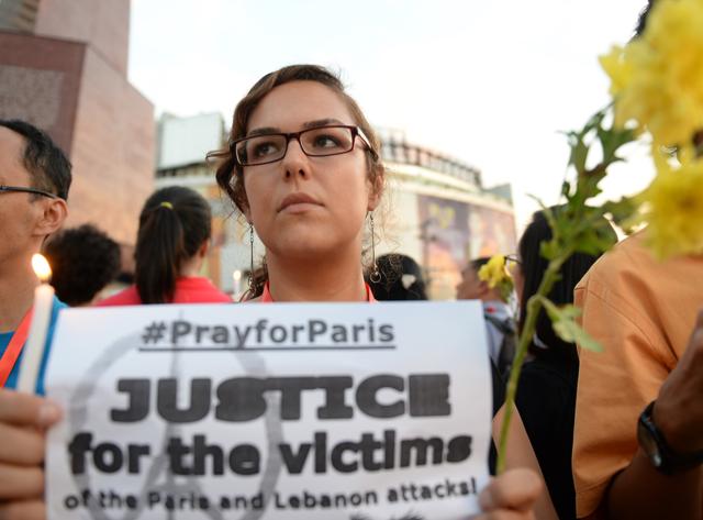 An activist holds a candle and a flower during a candle lighting ceremony condemning the Paris attacks, in Manila on November 15, 2015. (AFP) An activist holds a candle and a flower during a candle lighting ceremony condemning the Paris attacks, in Manila on November 15, 2015. (AFP)