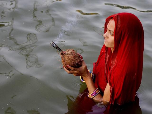 Hindu devotees offer prayers during Chhath festival on the banks of the river Yamuna, in New Delhi. (Sonu Mehta/HT Photo)