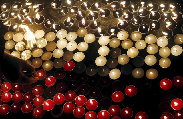 People light candles, as they form the French flag, in remembrance of the victims of the Paris attacks at Sant Jaume square in Barcelona. (REUTERS) People light candles, as they form the French flag, in remembrance of the victims of the Paris attacks at Sant Jaume square in Barcelona. (REUTERS)