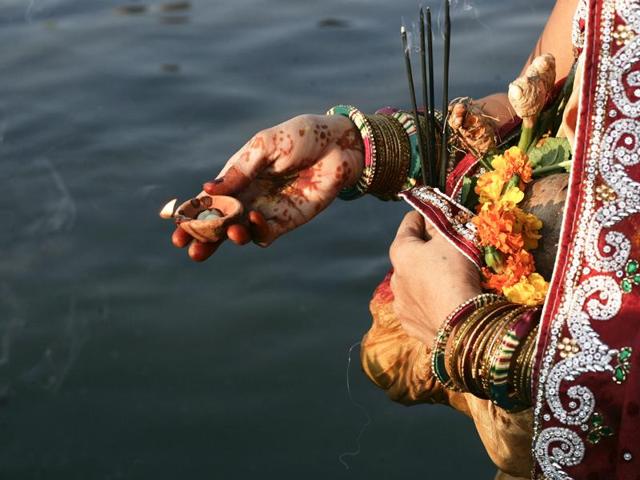 Hindu devotees offer prayers during Chhath Puja on the banks of river Yamuna, in Noida. (Burhaan Kinu /HT Photo)
