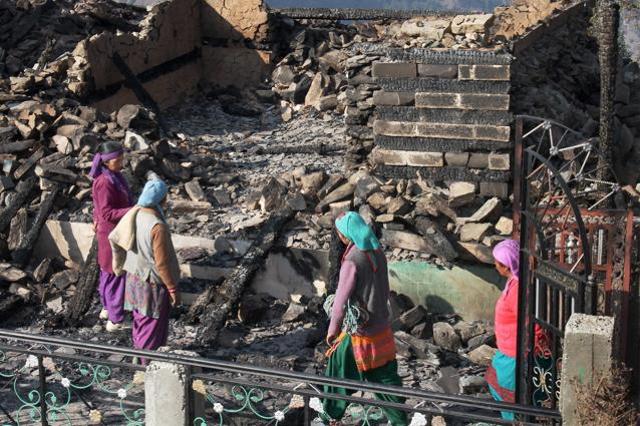 Women sifting through what is left of their homes after the fire on Sunday night destroyed as many as 72 houses in the village. (PTI) Women sifting through what is left of their homes after the fire on Sunday night destroyed as many as 72 houses in the village. (PTI)