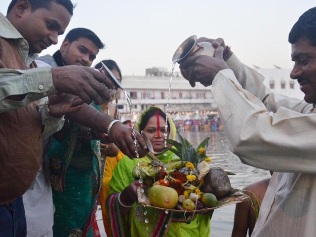 Devotees offer prayers while standing in the water tank at Durgiana Temple in Amritsar on Tuesday. (Sameer Sehgal/HT Photo)